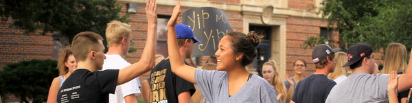 College students high-five while walking on campus.