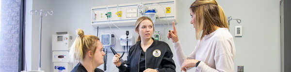 Nursing students with Professor Brittney Fritzinger in a nursing lab.