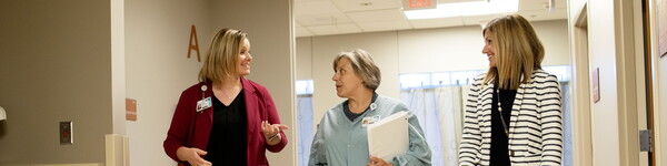 A nurse walks with two nurse administrators who received a Master of Nursing.